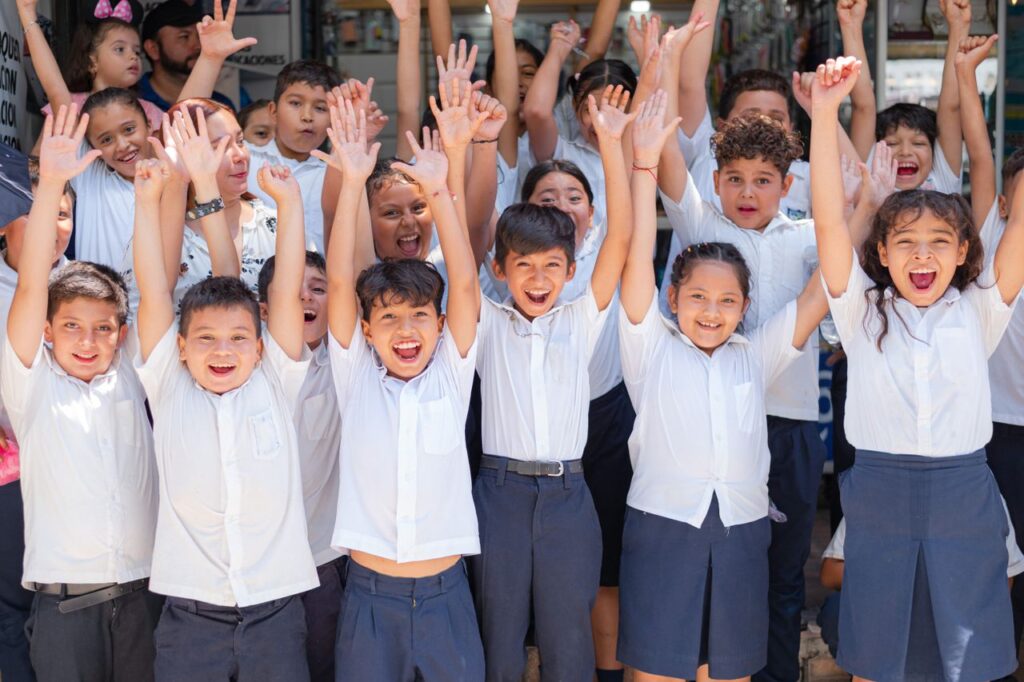 Competențe digitale pentru profesorii viitorului Joyful group of school children in Santa Rosa de Lima, El Salvador cheering outdoors.